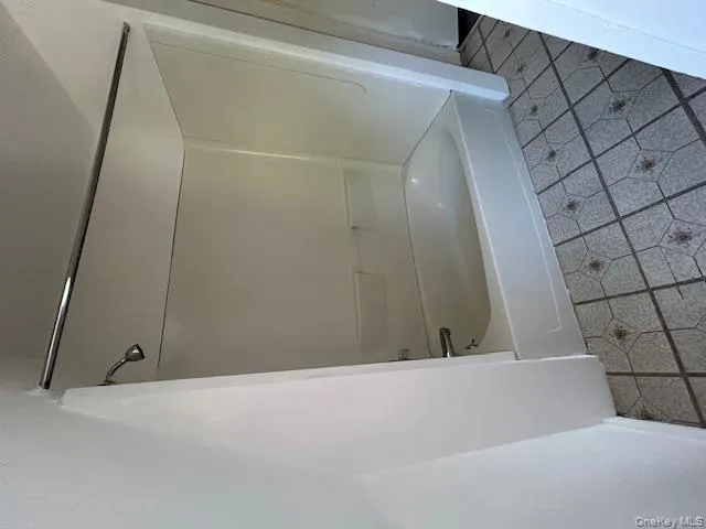 Bathroom with light tile patterned floors and bathing tub / shower combination Bathroom with light tile patterned floors and bathing tub / shower combination