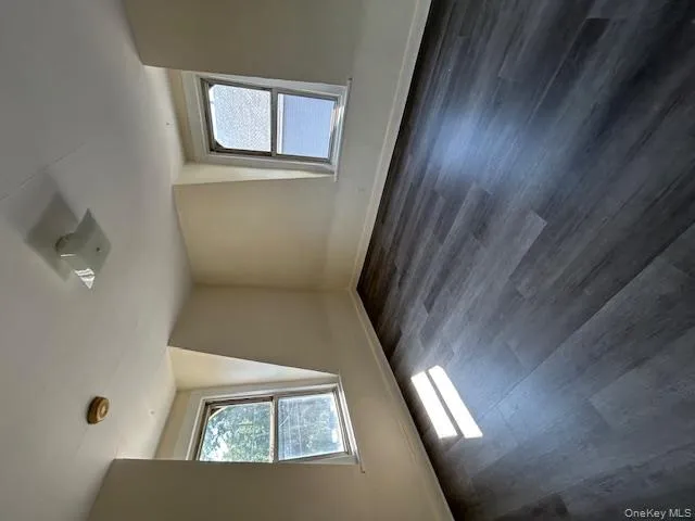 Additional living space with dark wood-type flooring and plenty of natural light Additional living space with dark wood-type flooring and plenty of natural light