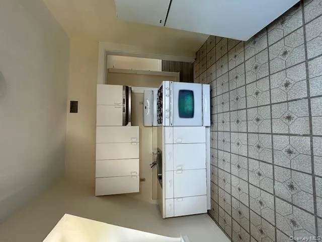 Kitchen featuring white range with gas cooktop, refrigerator, white cabinetry, and light countertops Kitchen featuring white range with gas cooktop, refrigerator, white cabinetry, and light countertops