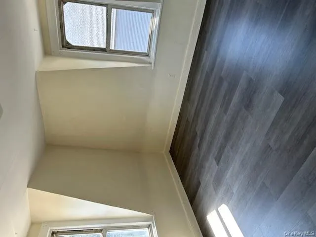 Additional living space with plenty of natural light and dark wood-type flooring Additional living space with plenty of natural light and dark wood-type flooring