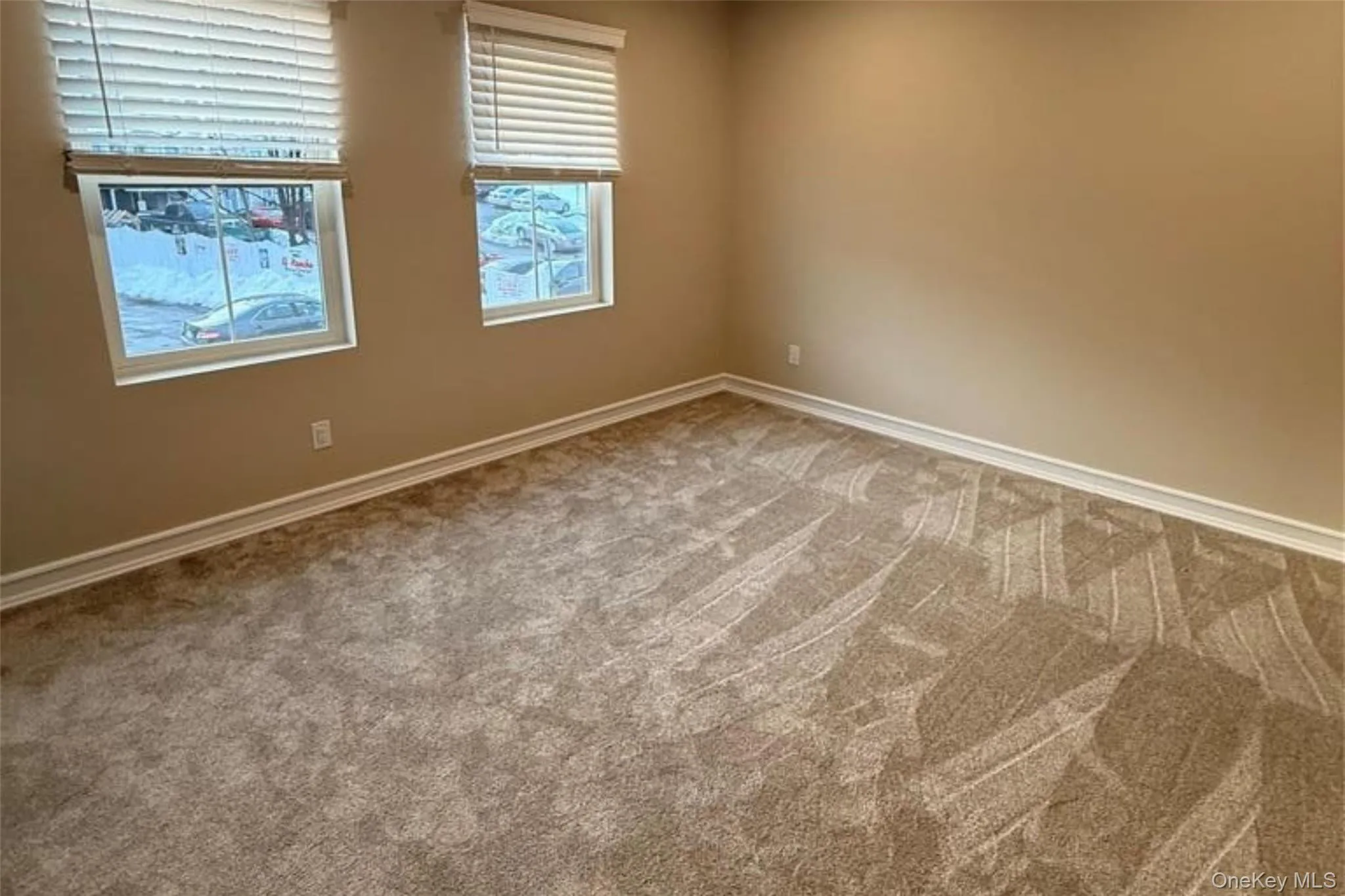 Spare room featuring baseboards and carpet Spare room featuring baseboards and carpet