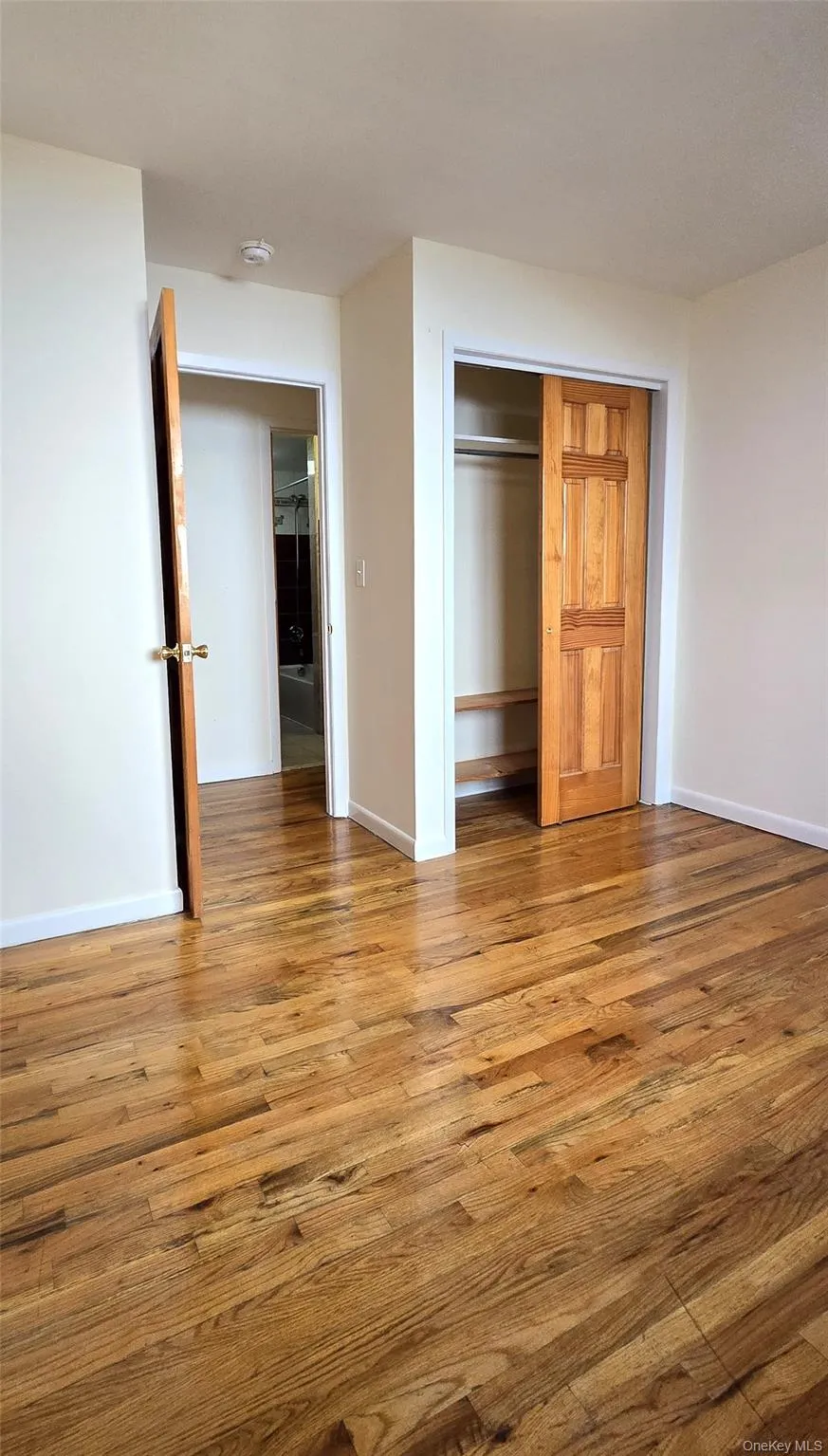 Unfurnished bedroom featuring a closet and wood finished floors Unfurnished bedroom featuring a closet and wood finished floors