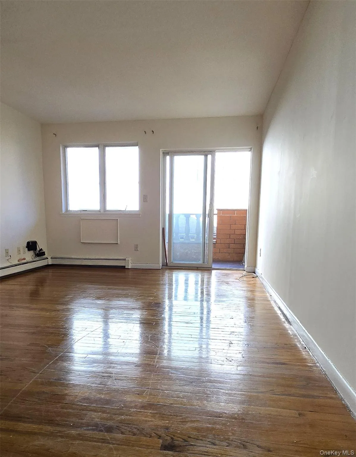 Unfurnished room with dark wood finished floors and plenty of natural light Unfurnished room with dark wood finished floors and plenty of natural light