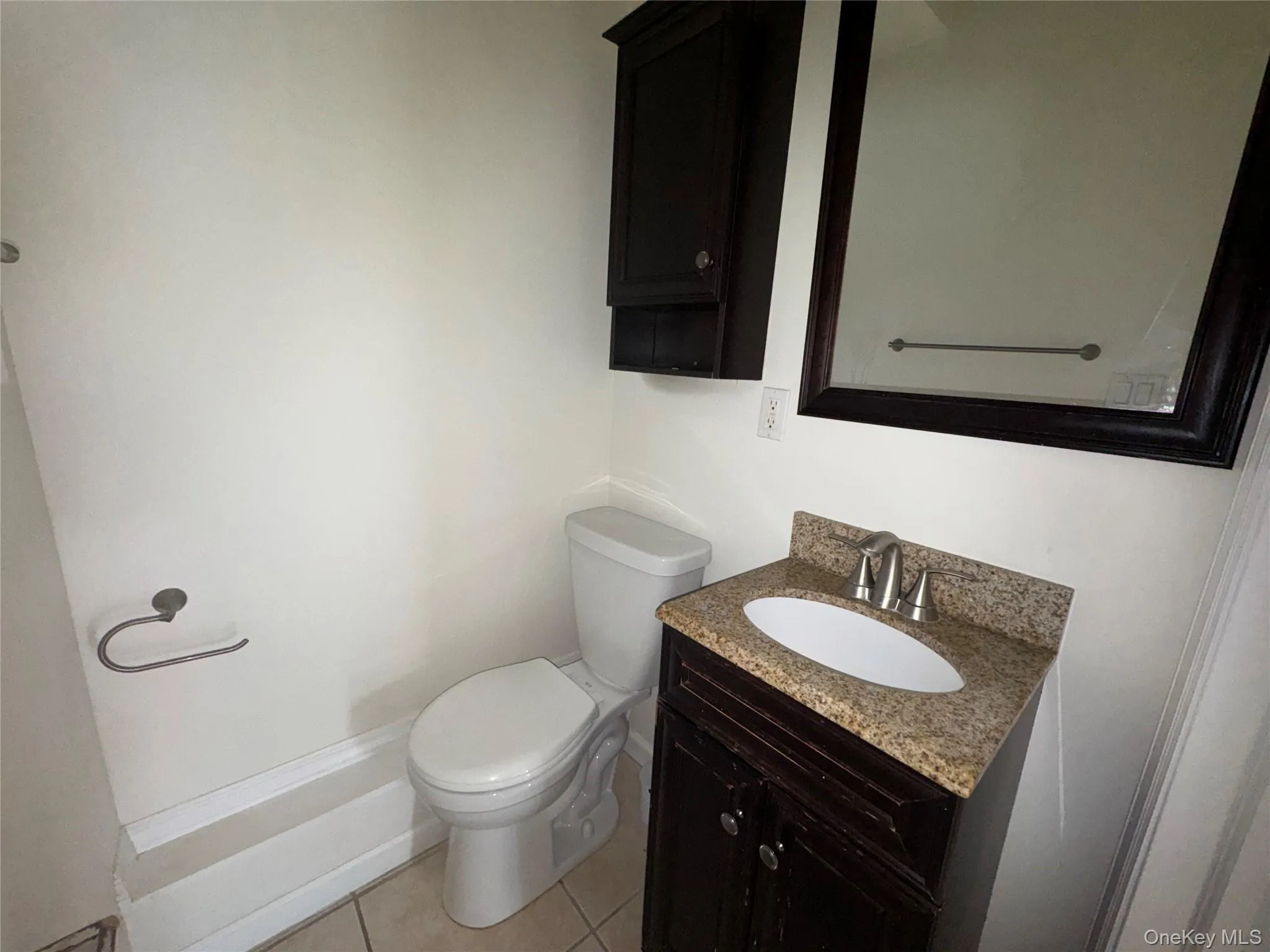 Half bath featuring vanity and light tile patterned flooring Half bath featuring vanity and light tile patterned flooring