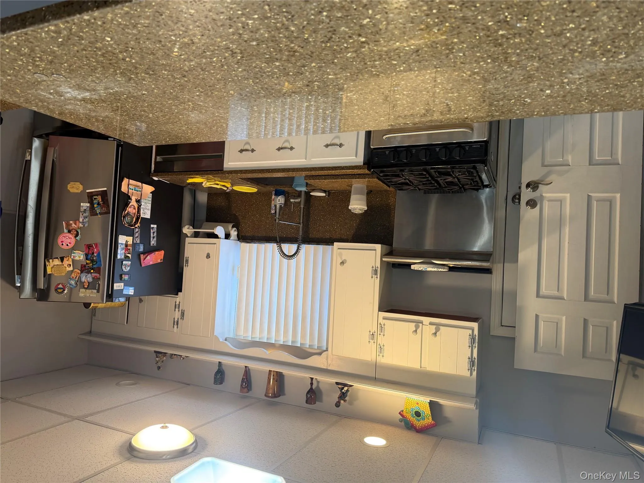 Kitchen featuring a paneled ceiling, stove, white cabinets, and dark stone countertops Kitchen featuring a paneled ceiling, stove, white cabinets, and dark stone countertops