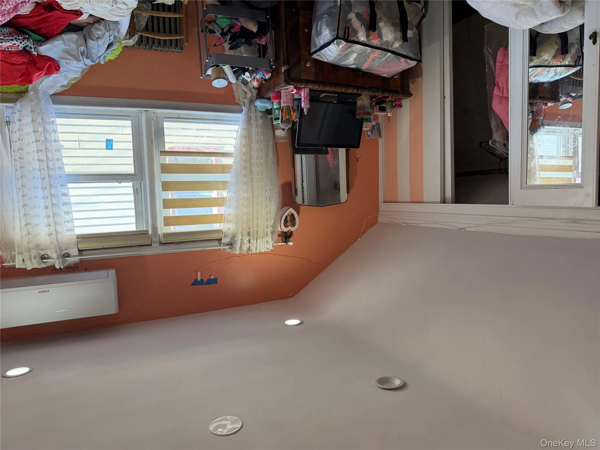 Bedroom with radiator, a wall mounted AC, vaulted ceiling, a closet, and recessed lighting Bedroom with radiator, a wall mounted AC, vaulted ceiling, a closet, and recessed lighting