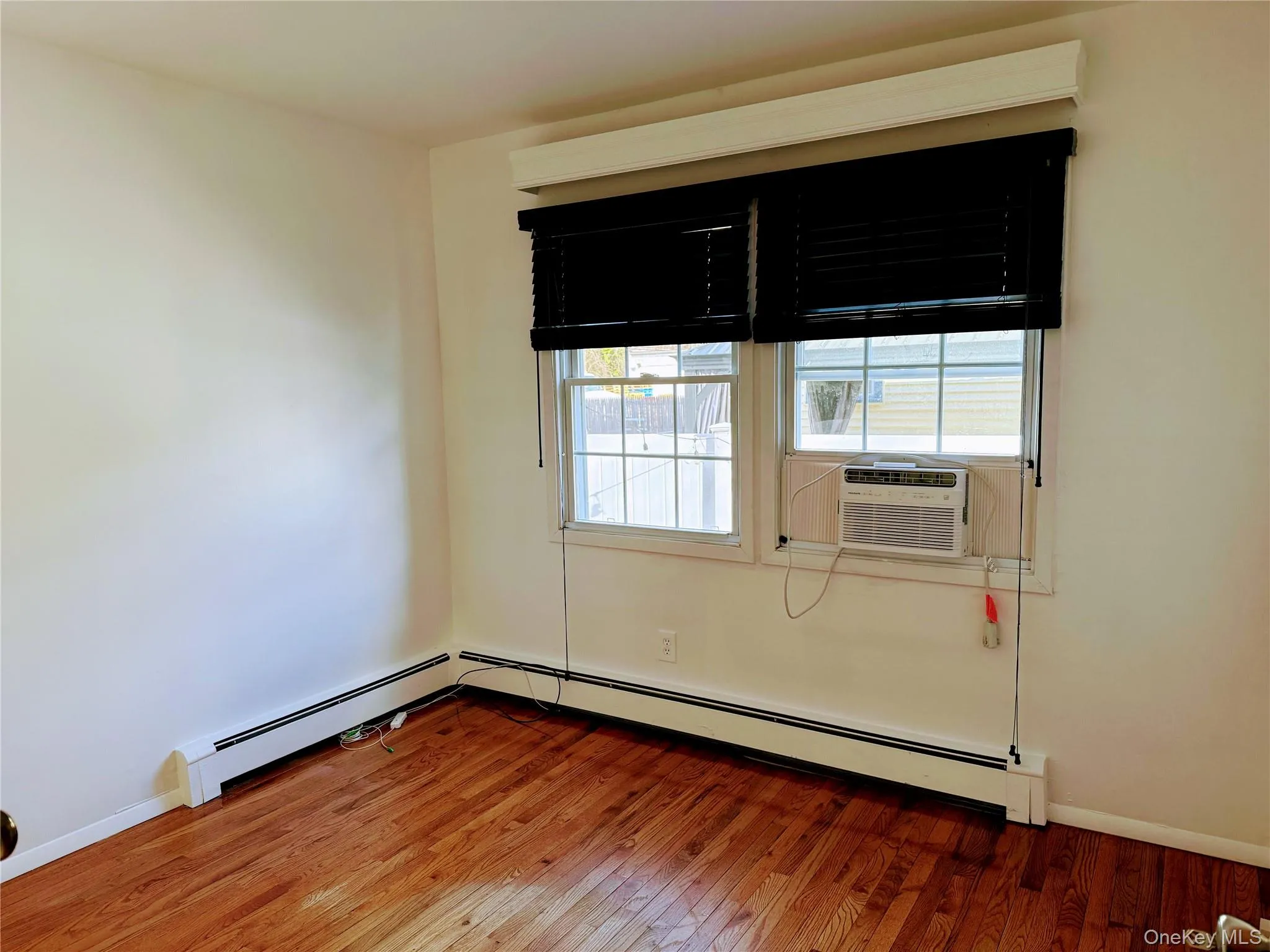 2nd Bedroom with hard wood flooring, baseboard heating, and window cooling unit 2nd Bedroom with hard wood flooring, baseboard heating, and window cooling unit