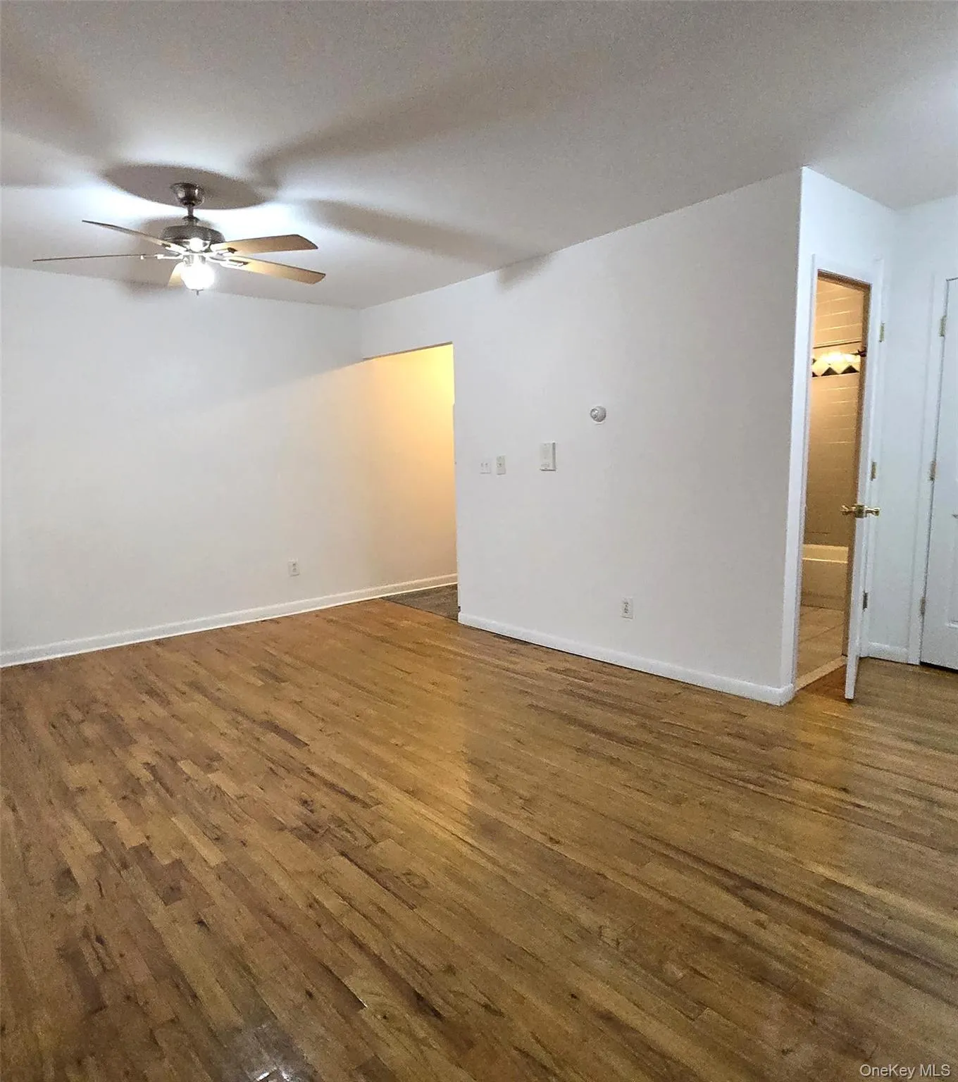 Spare room with dark wood-style flooring and ceiling fan Spare room with dark wood-style flooring and ceiling fan