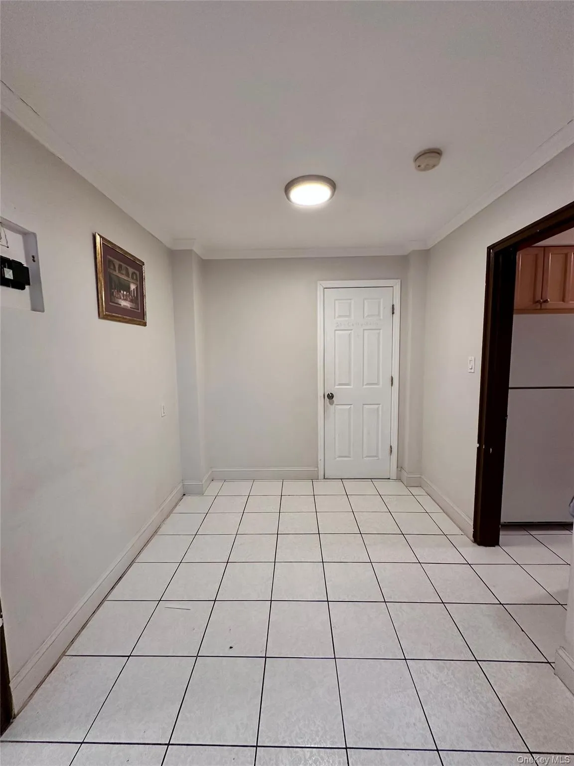 Empty room with crown molding and light tile patterned floors Empty room with crown molding and light tile patterned floors