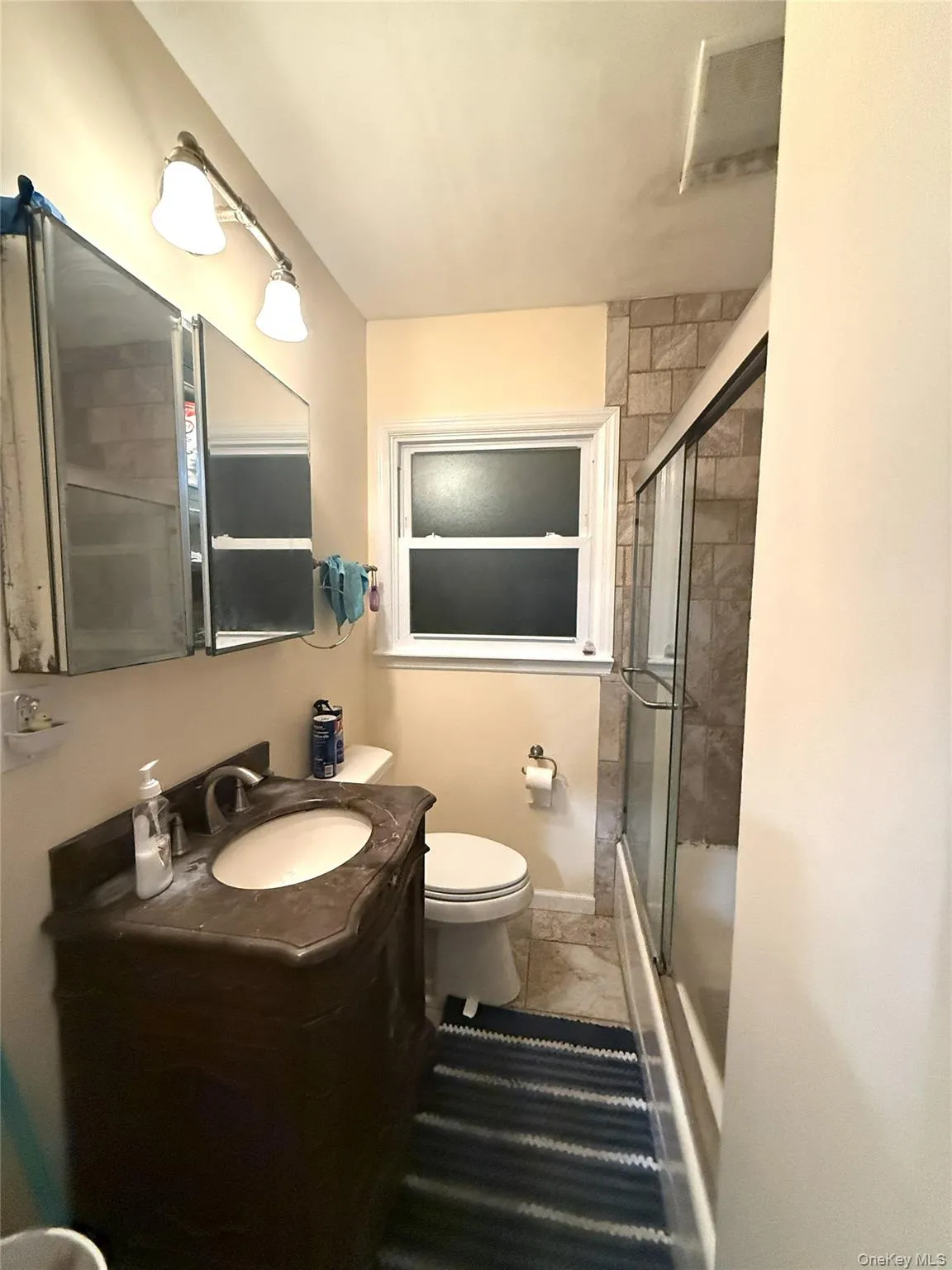 Full bath featuring vanity and shower / bath combination with glass door Full bath featuring vanity and shower / bath combination with glass door