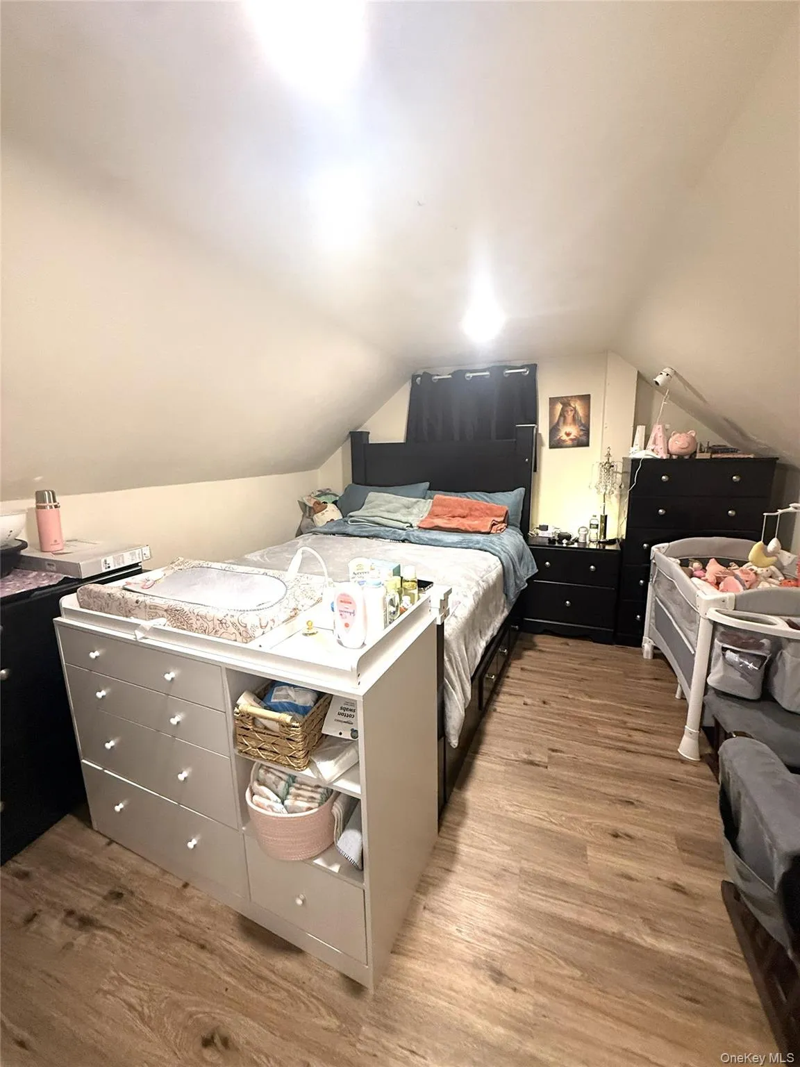 Bedroom with lofted ceiling and light wood-style floors Bedroom with lofted ceiling and light wood-style floors