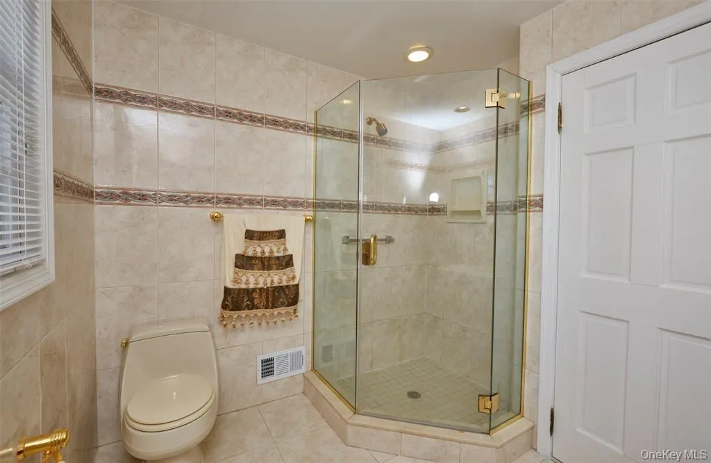 Bathroom featuring a stall shower, tile patterned flooring, tile walls, and recessed lighting Bathroom featuring a stall shower, tile patterned flooring, tile walls, and recessed lighting