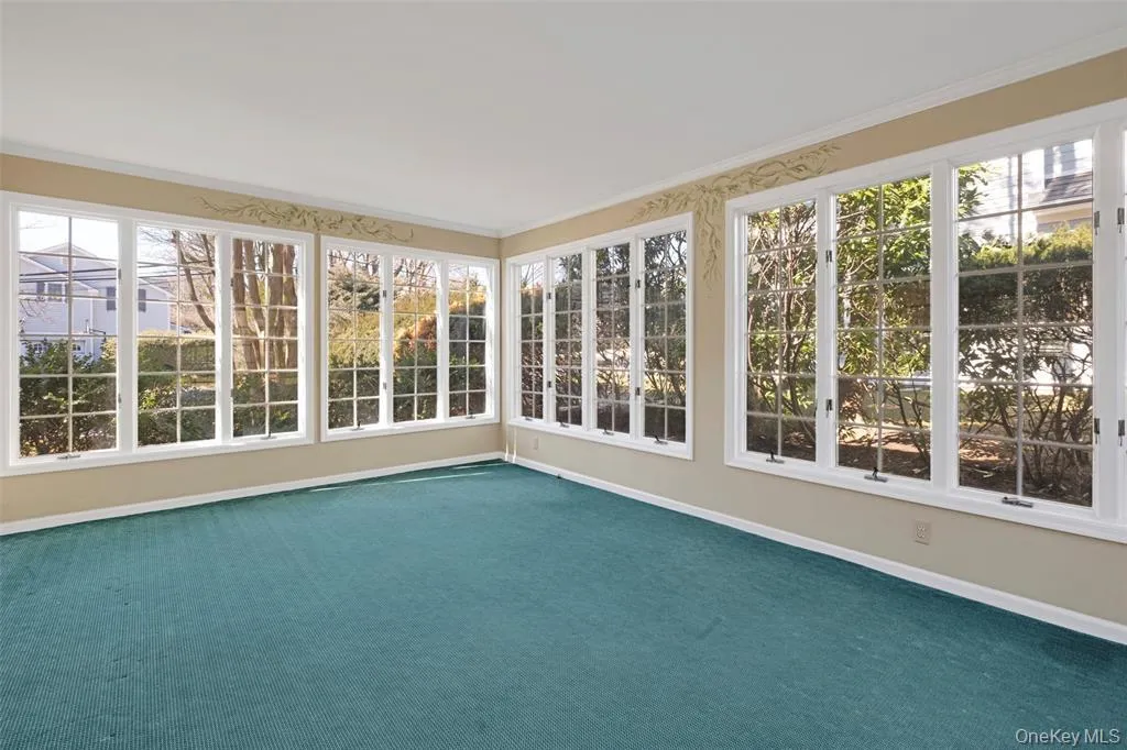 Unfurnished sunroom featuring carpet and crown molding Unfurnished sunroom featuring carpet and crown molding