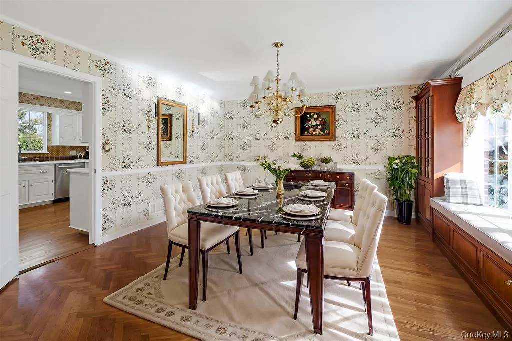 Dining room featuring wallpapered walls, a chandelier, and a wainscoted wall Dining room featuring wallpapered walls, a chandelier, and a wainscoted wall
