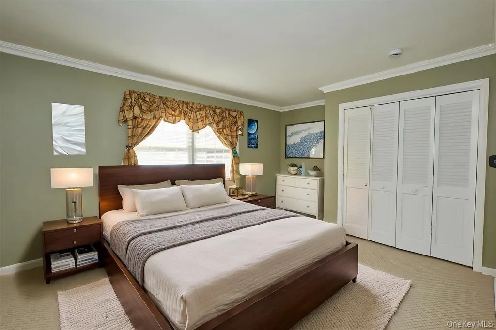 Carpeted bedroom with a closet and ornamental molding Carpeted bedroom with a closet and ornamental molding
