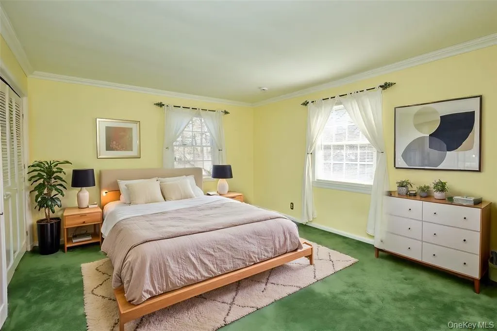 Carpeted bedroom with crown molding and a closet Carpeted bedroom with crown molding and a closet