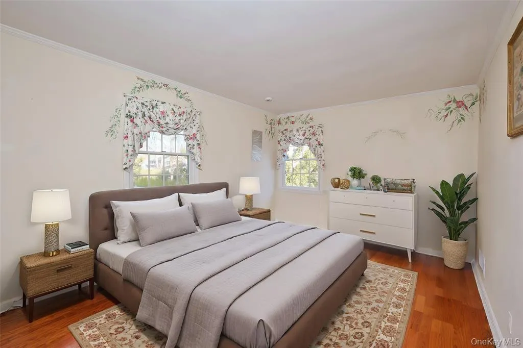 Bedroom with crown molding and wood finished floors Bedroom with crown molding and wood finished floors