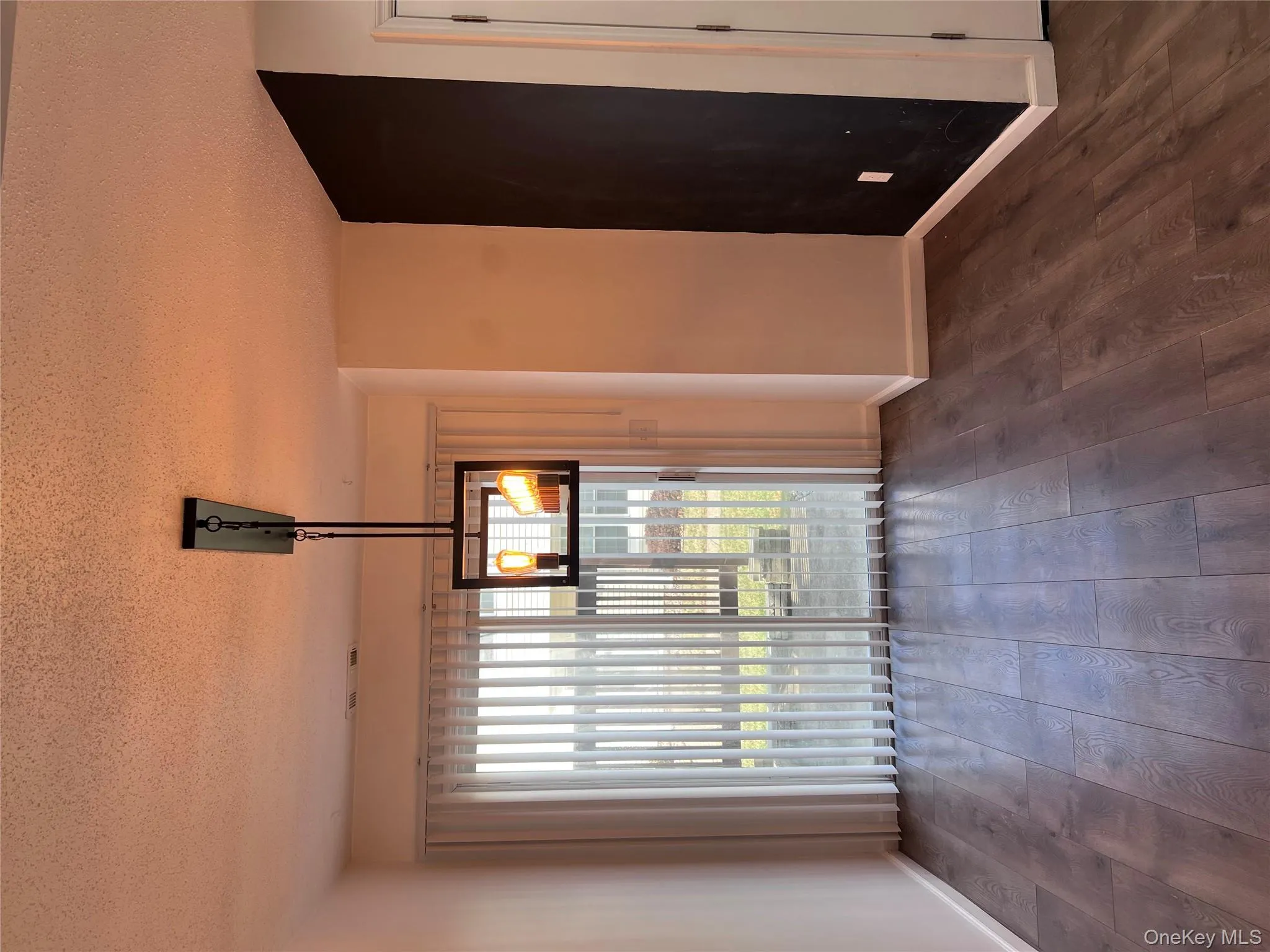 Unfurnished dining area featuring a textured ceiling and dark wood-type flooring Unfurnished dining area featuring a textured ceiling and dark wood-type flooring