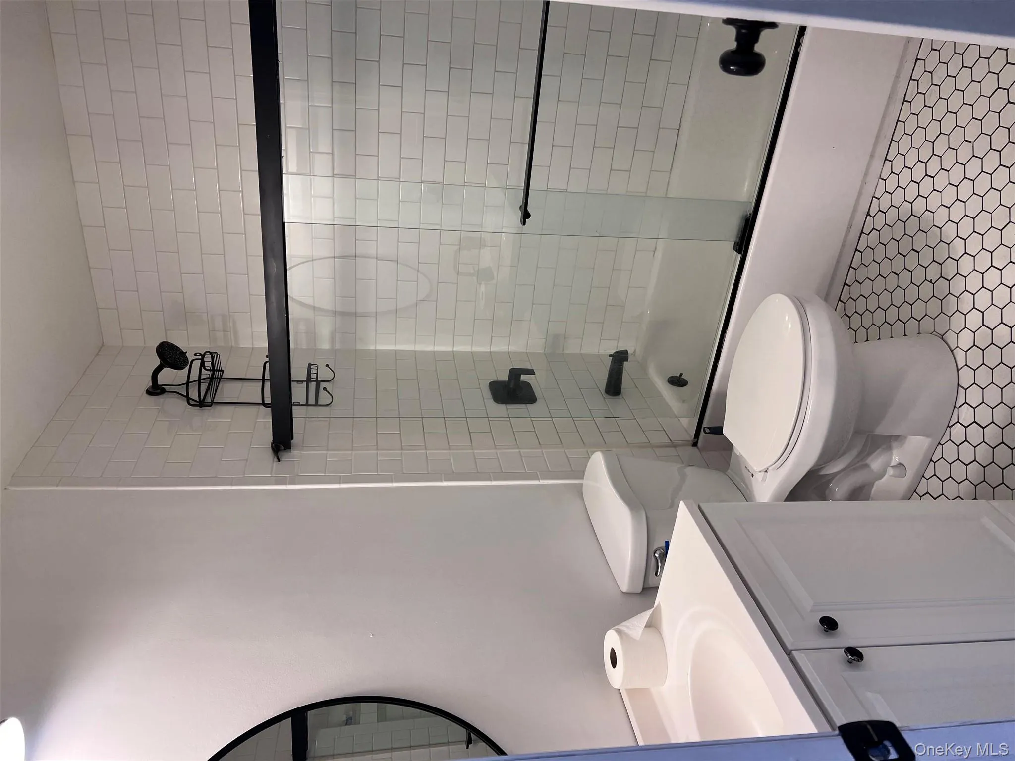 Full bathroom with tile patterned floors, vanity, toilet, and bath / shower combo with glass door Full bathroom with tile patterned floors, vanity, toilet, and bath / shower combo with glass door