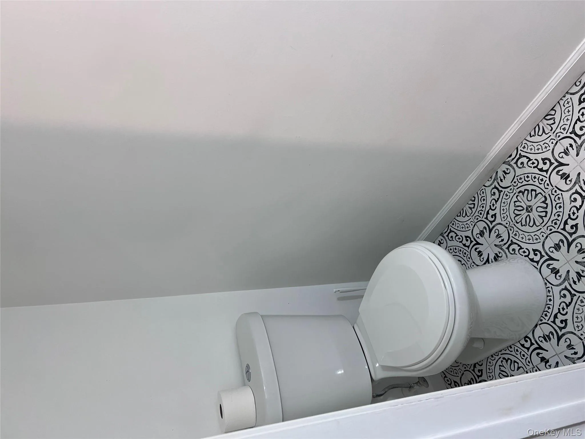 Bathroom featuring tile patterned flooring and toilet Bathroom featuring tile patterned flooring and toilet