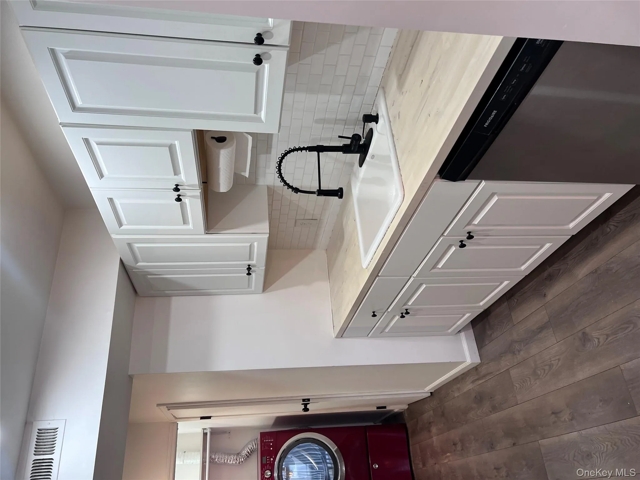 Kitchen featuring white cabinets, dishwasher, sink, and washer / clothes dryer Kitchen featuring white cabinets, dishwasher, sink, and washer / clothes dryer