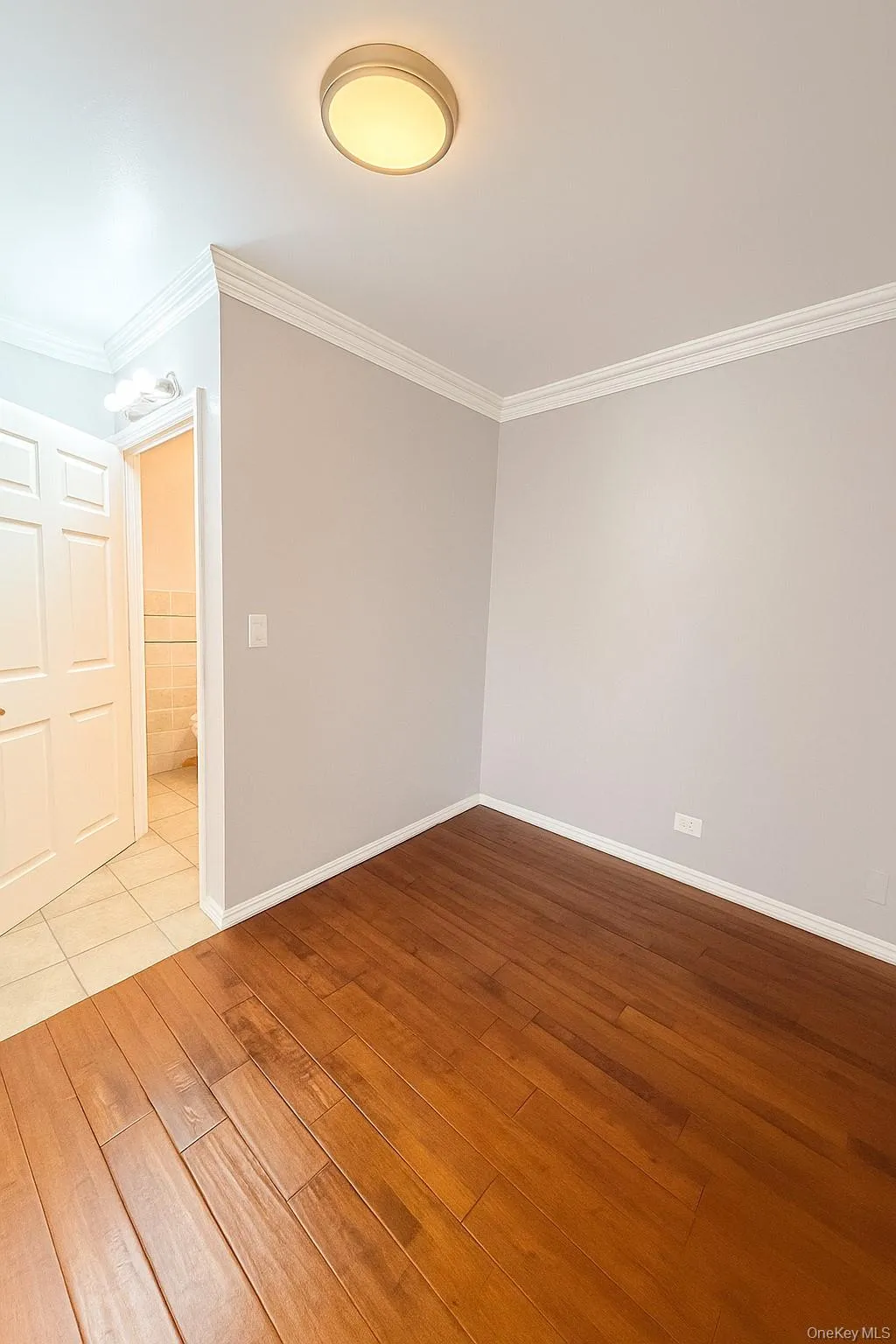 Unfurnished room with wood finished floors and ornamental molding Unfurnished room with wood finished floors and ornamental molding