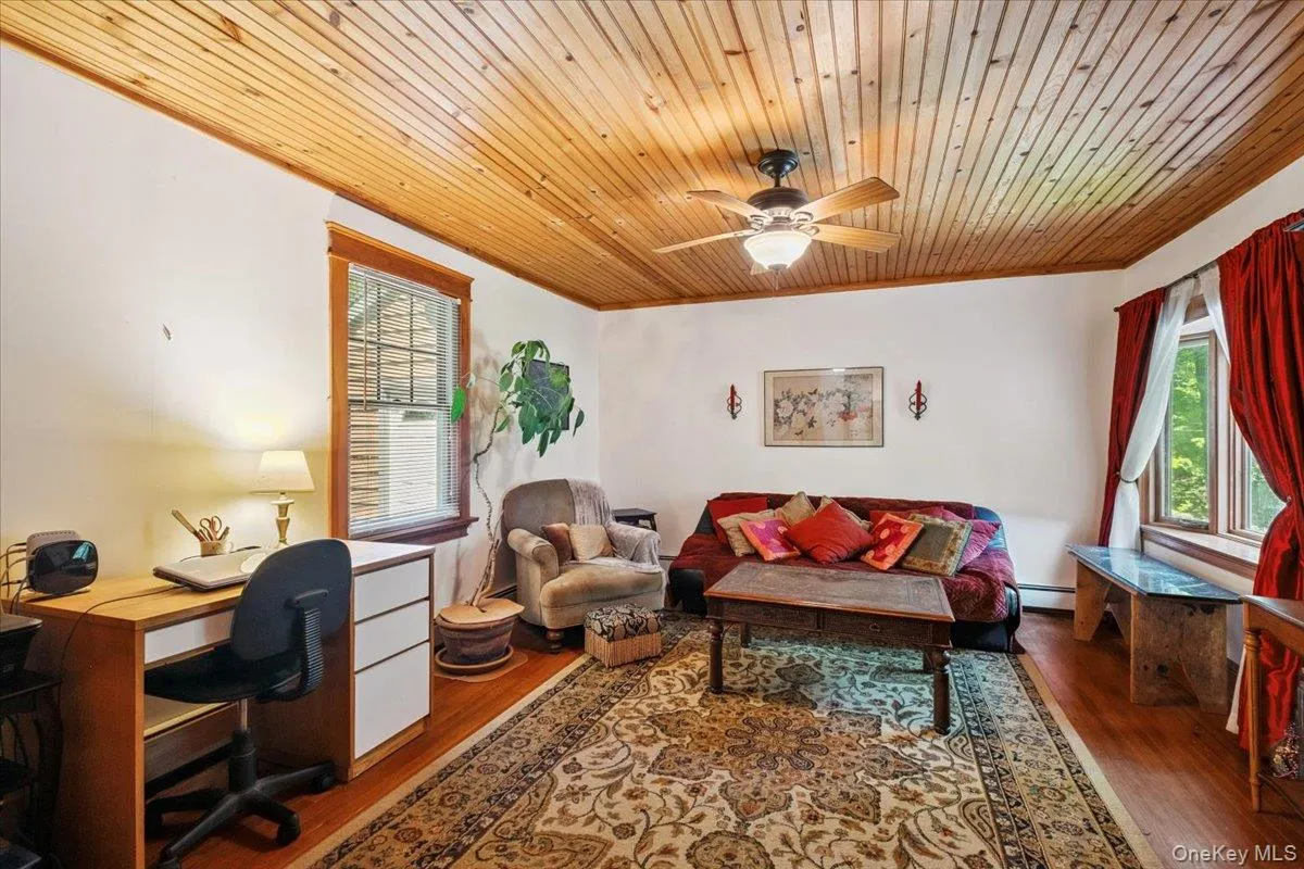Office with wood finished floors, wooden ceiling, ceiling fan, ornamental molding, and a baseboard radiator Office with wood finished floors, wooden ceiling, ceiling fan, ornamental molding, and a baseboard radiator