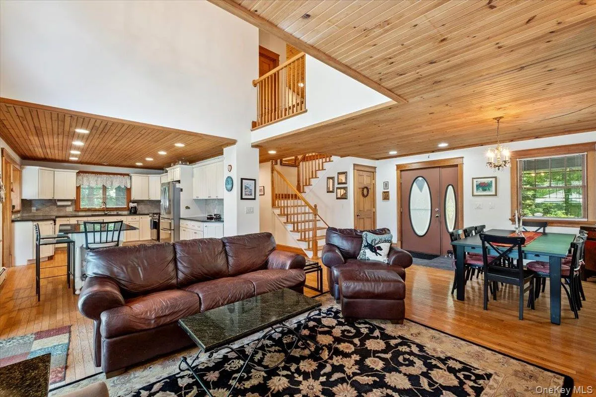 Living area with wood ceiling, light wood-type flooring, a chandelier, stairs, and recessed lighting Living area with wood ceiling, light wood-type flooring, a chandelier, stairs, and recessed lighting