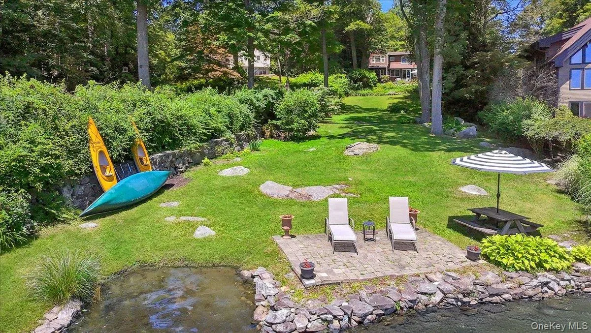 View of beach area with patio and grassy yard featuring a patio View of beach area with patio and grassy yard featuring a patio