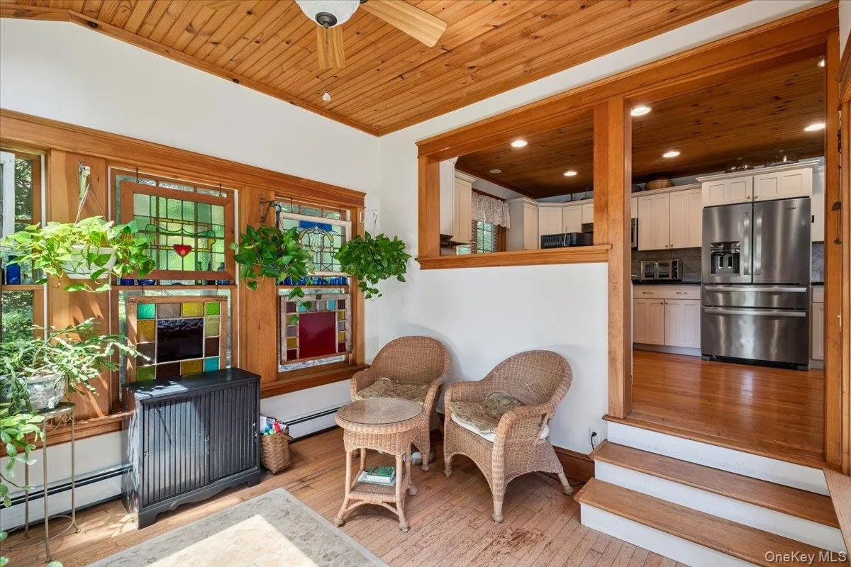 Sitting room featuring wooden ceiling, hardwood / wood-style flooring, baseboard heating, ceiling fan, and plenty of natural light Sitting room featuring wooden ceiling, hardwood / wood-style flooring, baseboard heating, ceiling fan, and plenty of natural light