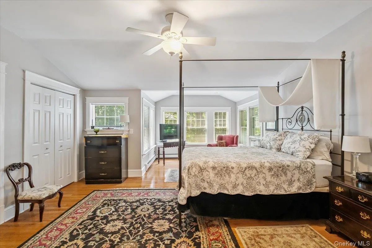 Bedroom featuring vaulted ceiling, light wood-style floors, and a ceiling fan Bedroom featuring vaulted ceiling, light wood-style floors, and a ceiling fan