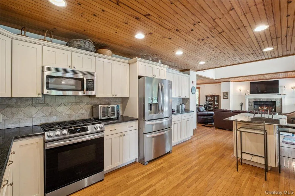 Kitchen with appliances with stainless steel finishes, open floor plan, light wood-style flooring, backsplash, and recessed lighting Kitchen with appliances with stainless steel finishes, open floor plan, light wood-style flooring, backsplash, and recessed lighting