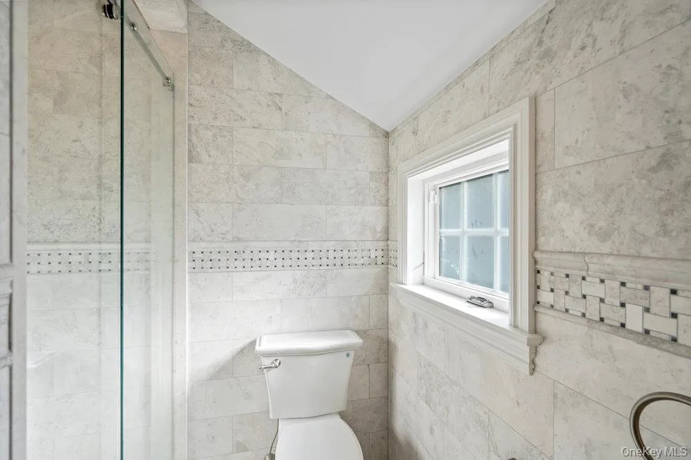 Bathroom with a stall shower and lofted ceiling Bathroom with a stall shower and lofted ceiling