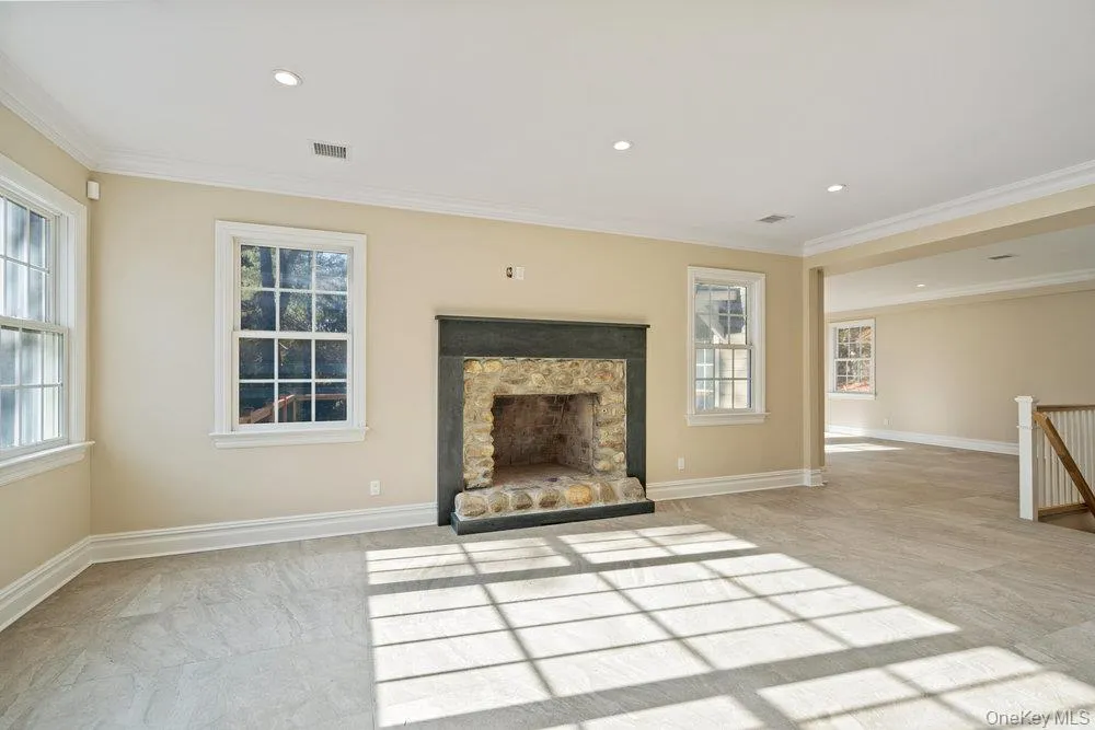 Unfurnished living room featuring ornamental molding, a fireplace, and recessed lighting Unfurnished living room featuring ornamental molding, a fireplace, and recessed lighting