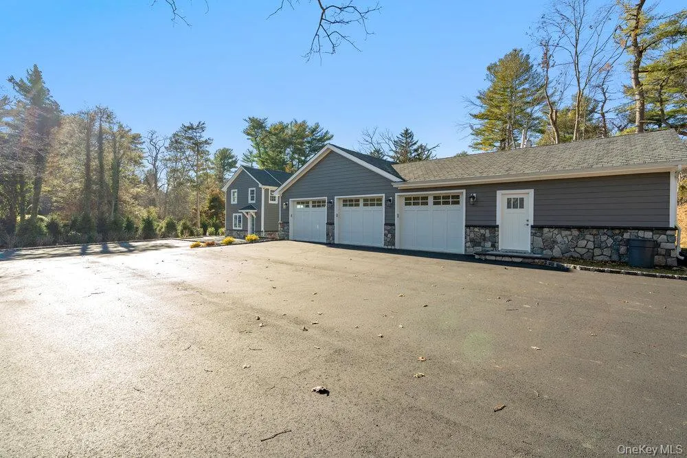 View of side of home featuring stone siding and driveway View of side of home featuring stone siding and driveway