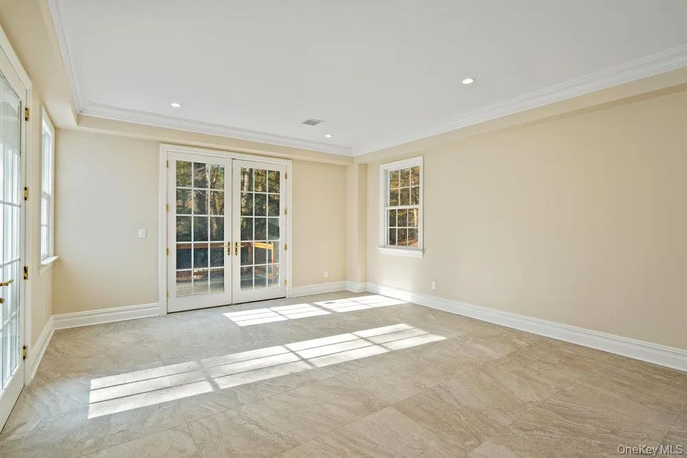 Unfurnished room with french doors, crown molding, recessed lighting, and light marble finish floors Unfurnished room with french doors, crown molding, recessed lighting, and light marble finish floors