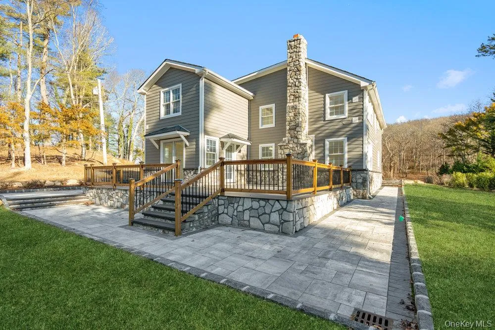 Rear view of property with a yard, a wooden deck, a patio, and a chimney Rear view of property with a yard, a wooden deck, a patio, and a chimney