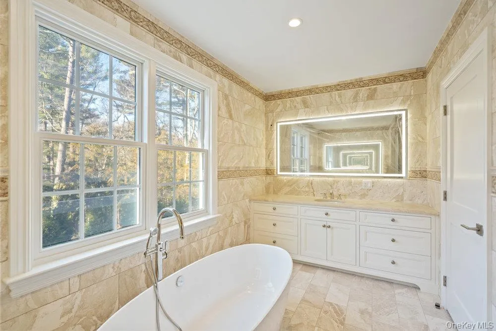 Bathroom featuring vanity, tile walls, and a freestanding bath Bathroom featuring vanity, tile walls, and a freestanding bath