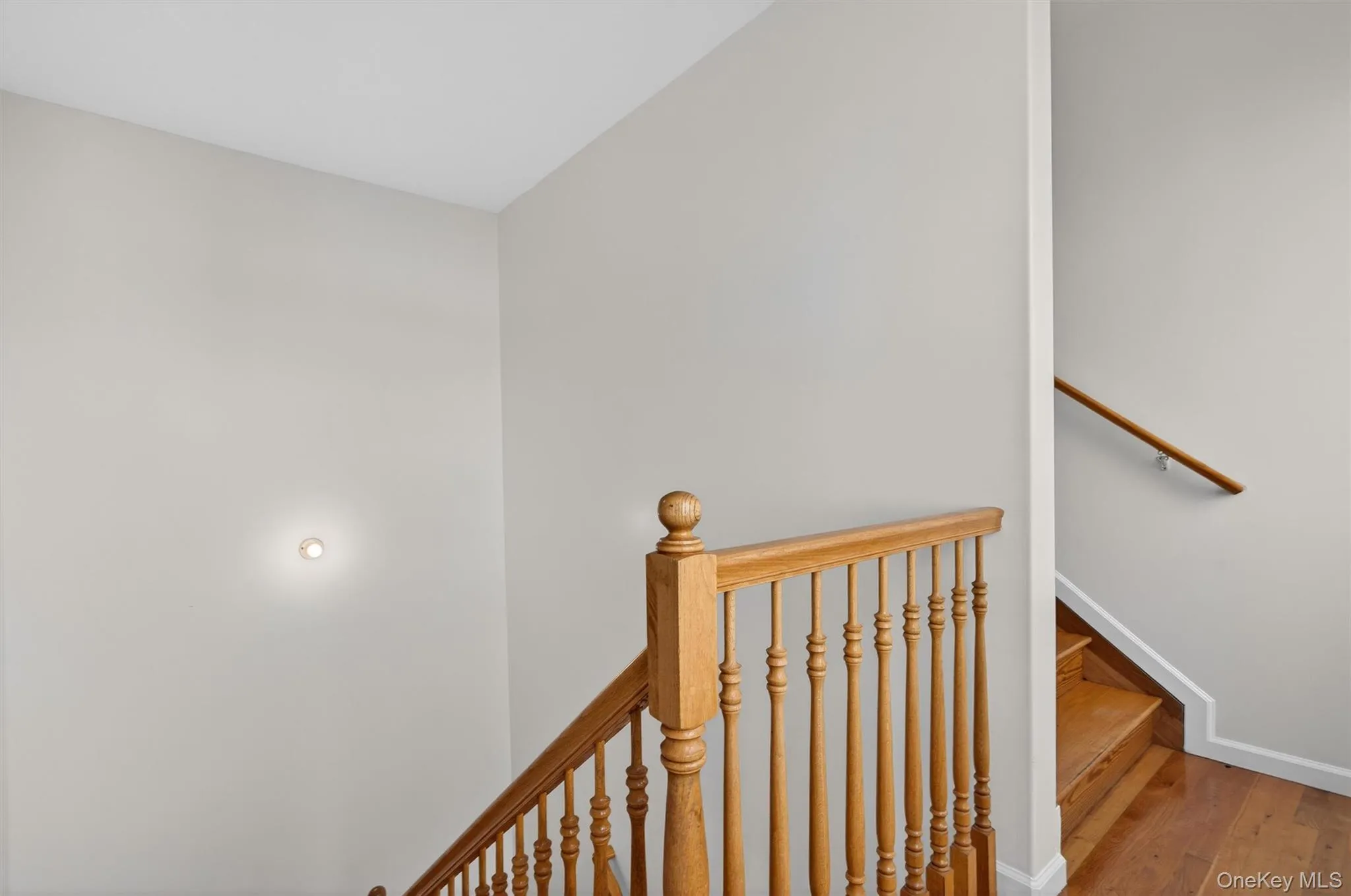 Staircase featuring hardwood / wood-style floors and baseboards Staircase featuring hardwood / wood-style floors and baseboards