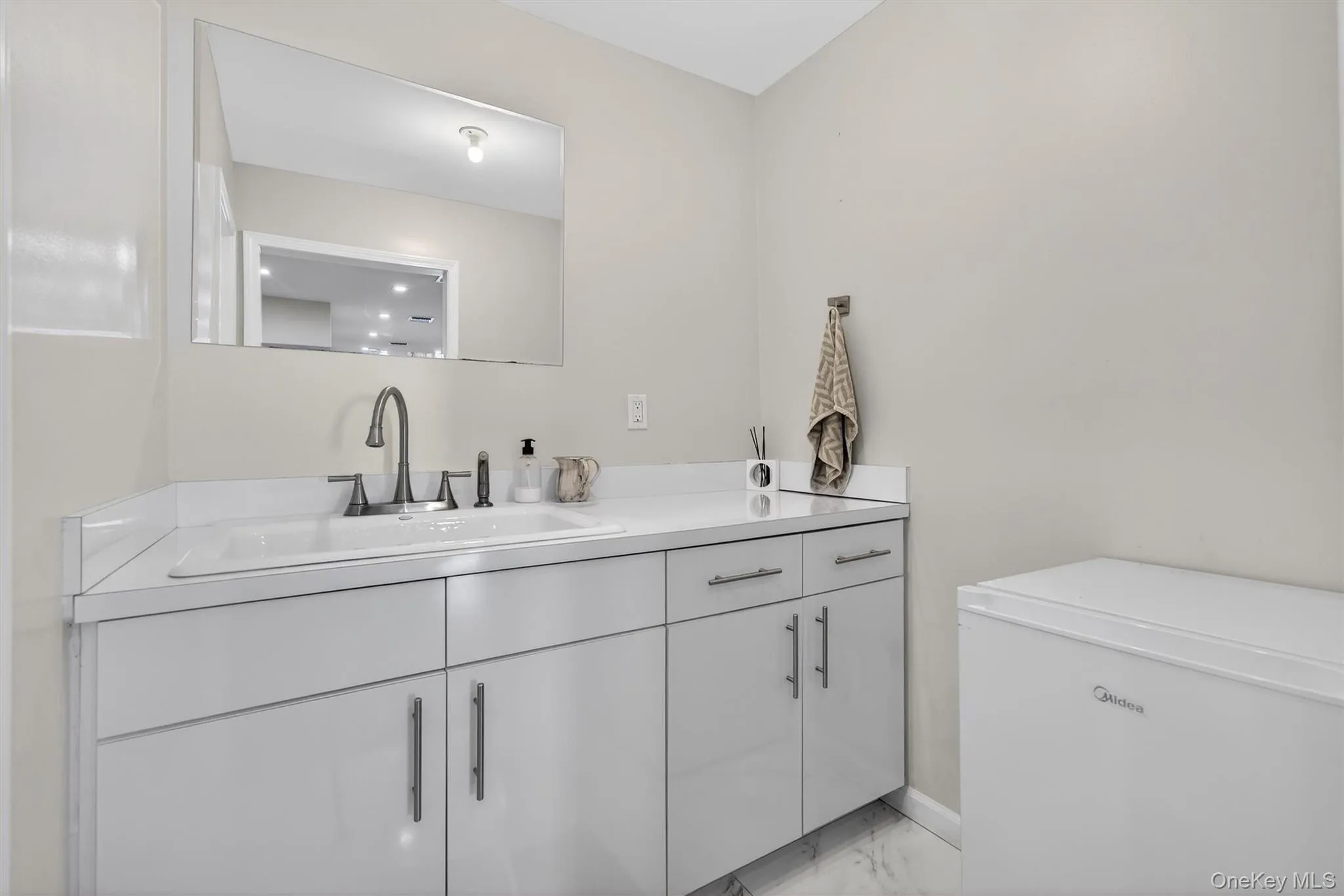 Bathroom with vanity and light marble finish floors Bathroom with vanity and light marble finish floors