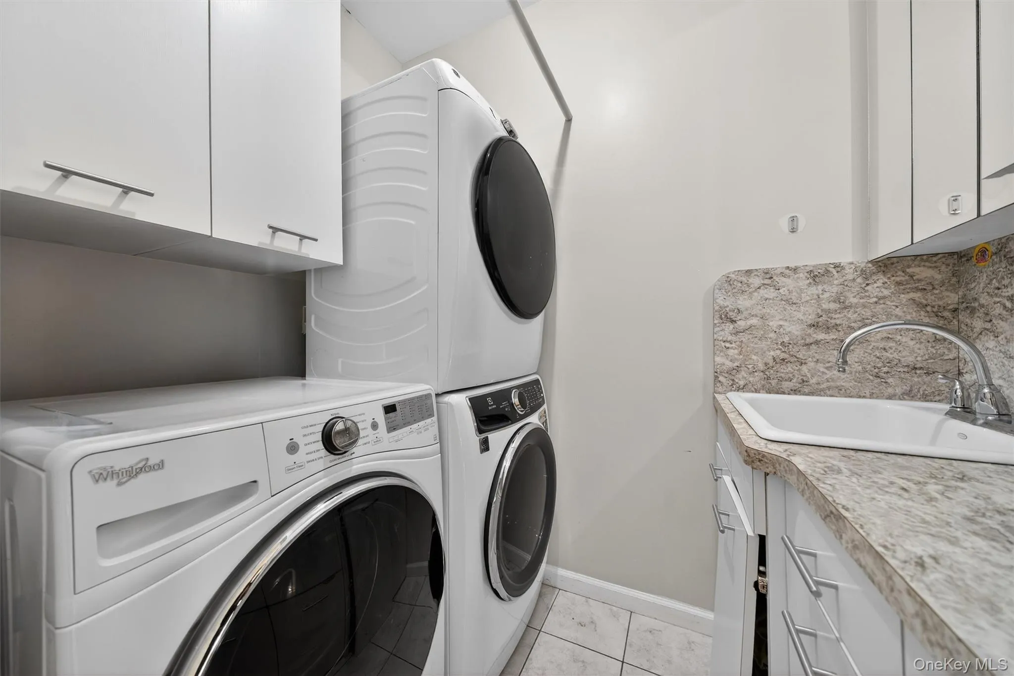 Laundry room with cabinet space and stacked washer / drying machine Laundry room with cabinet space and stacked washer / drying machine