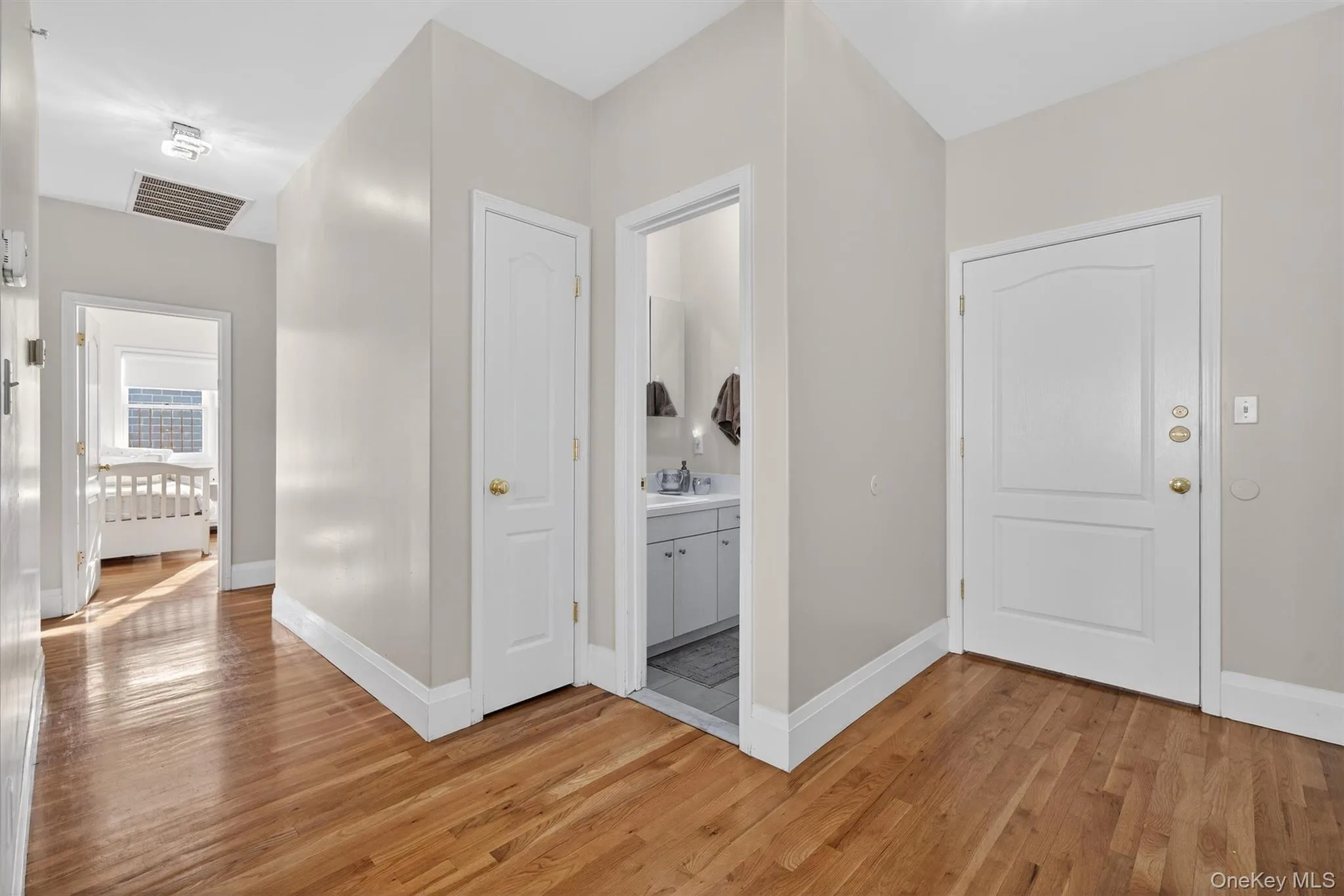 Hallway with light wood-type flooring and baseboards Hallway with light wood-type flooring and baseboards