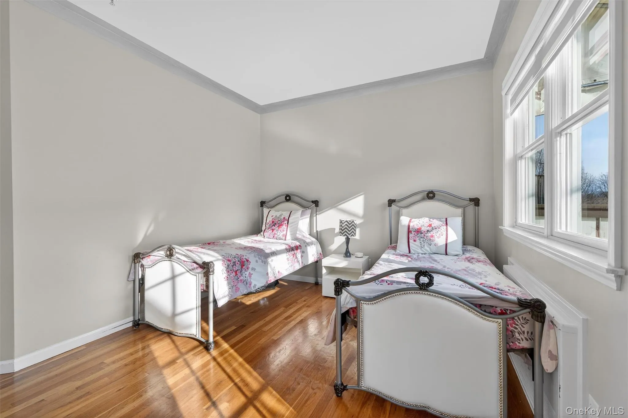 Bedroom featuring crown molding and wood finished floors Bedroom featuring crown molding and wood finished floors