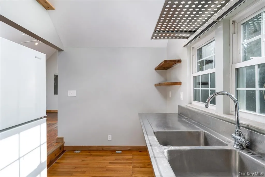 Kitchen with freestanding refrigerator, open shelves, and light wood finished floors Kitchen with freestanding refrigerator, open shelves, and light wood finished floors