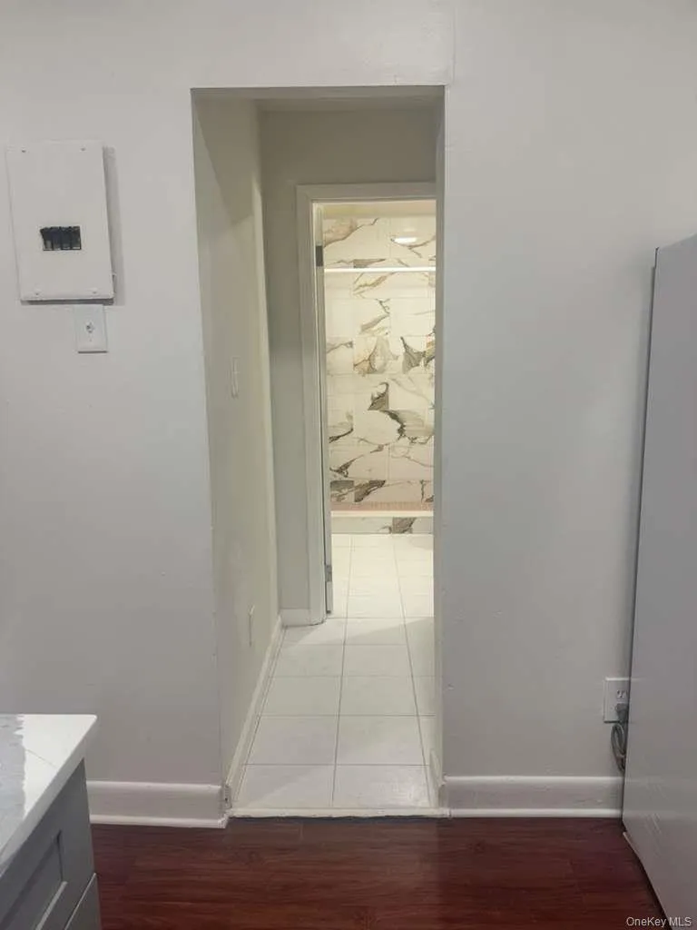 Corridor featuring dark wood-type flooring and electric panel Corridor featuring dark wood-type flooring and electric panel