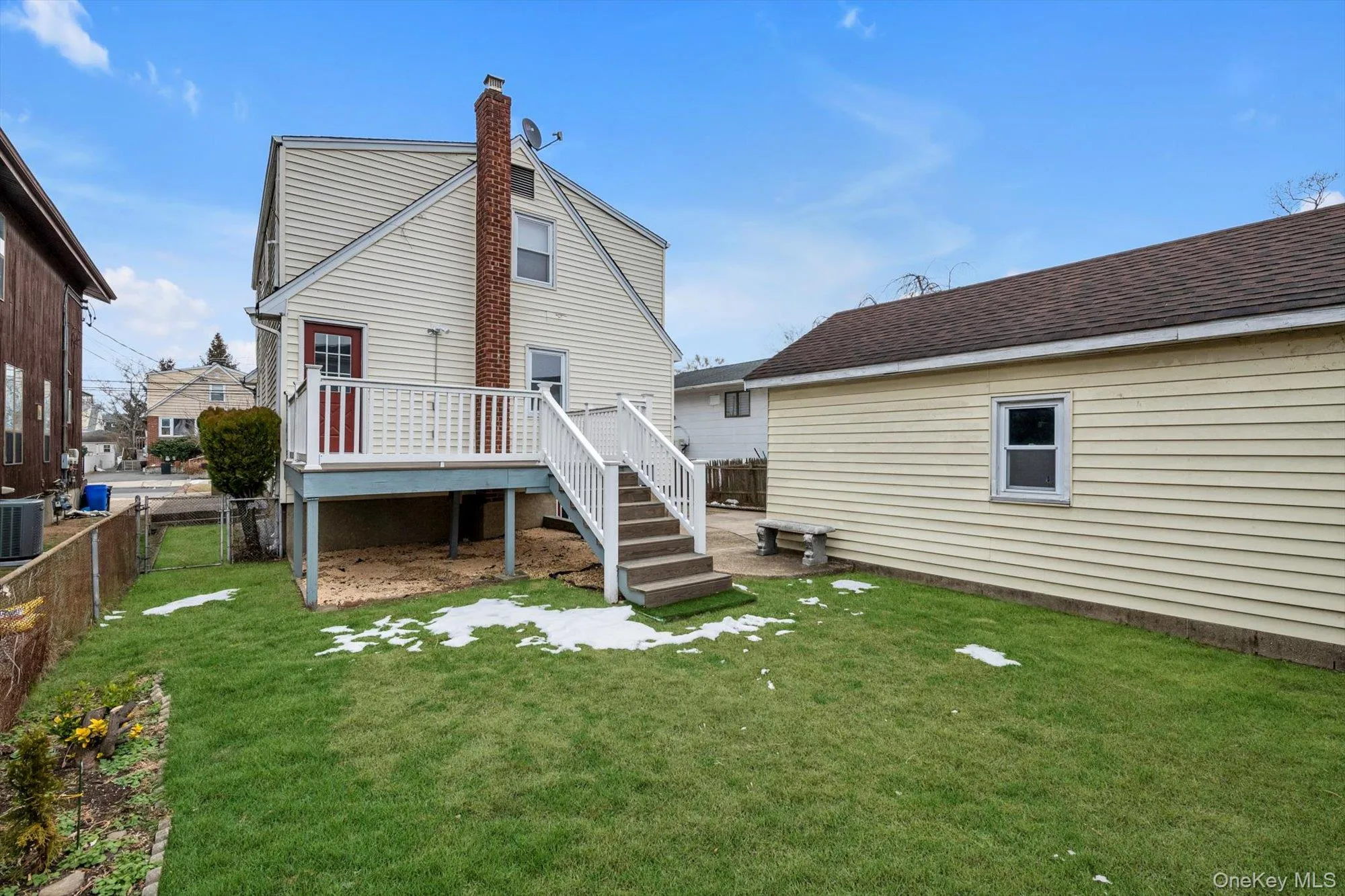 Back of house with a deck, a fenced backyard, stairway, and a chimney Back of house with a deck, a fenced backyard, stairway, and a chimney