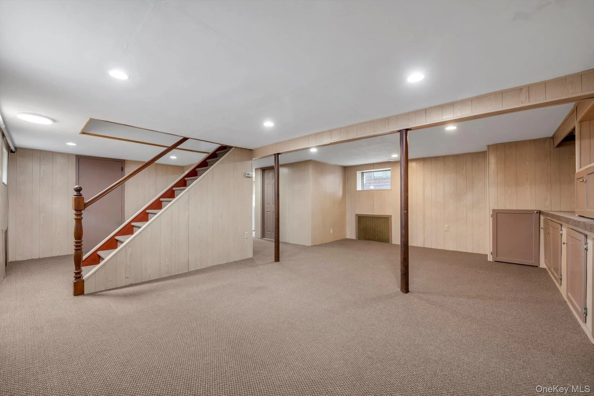 Below grade area featuring wooden walls, light carpet, recessed lighting, and stairway Below grade area featuring wooden walls, light carpet, recessed lighting, and stairway