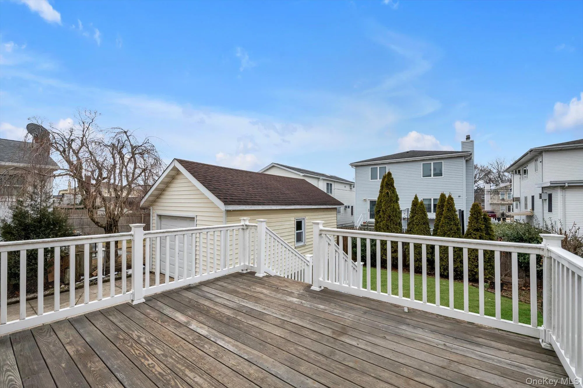 Wooden deck featuring a residential view, a garage, and an outdoor structure Wooden deck featuring a residential view, a garage, and an outdoor structure