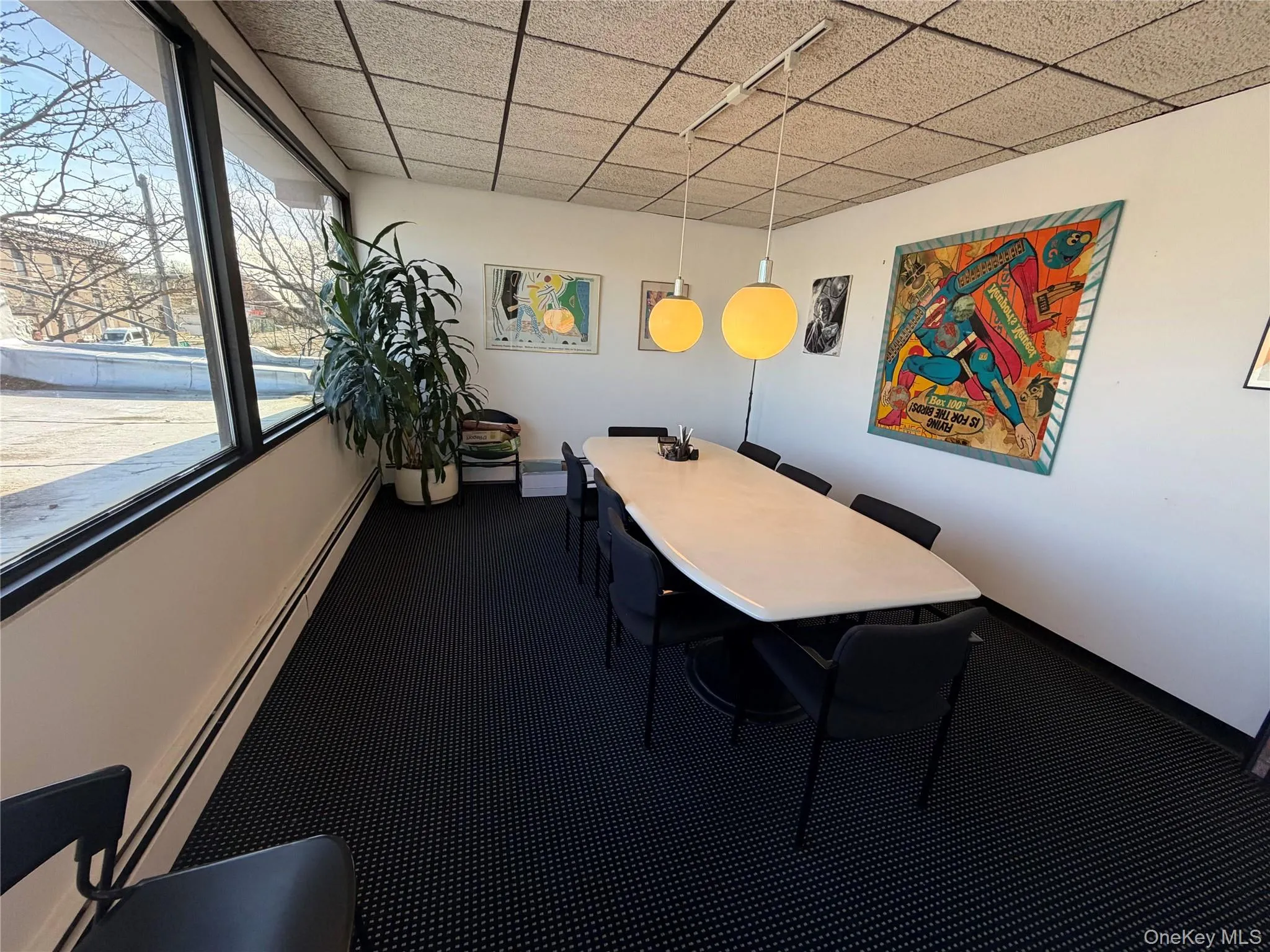 Dining room featuring a baseboard heating unit and a drop ceiling Dining room featuring a baseboard heating unit and a drop ceiling