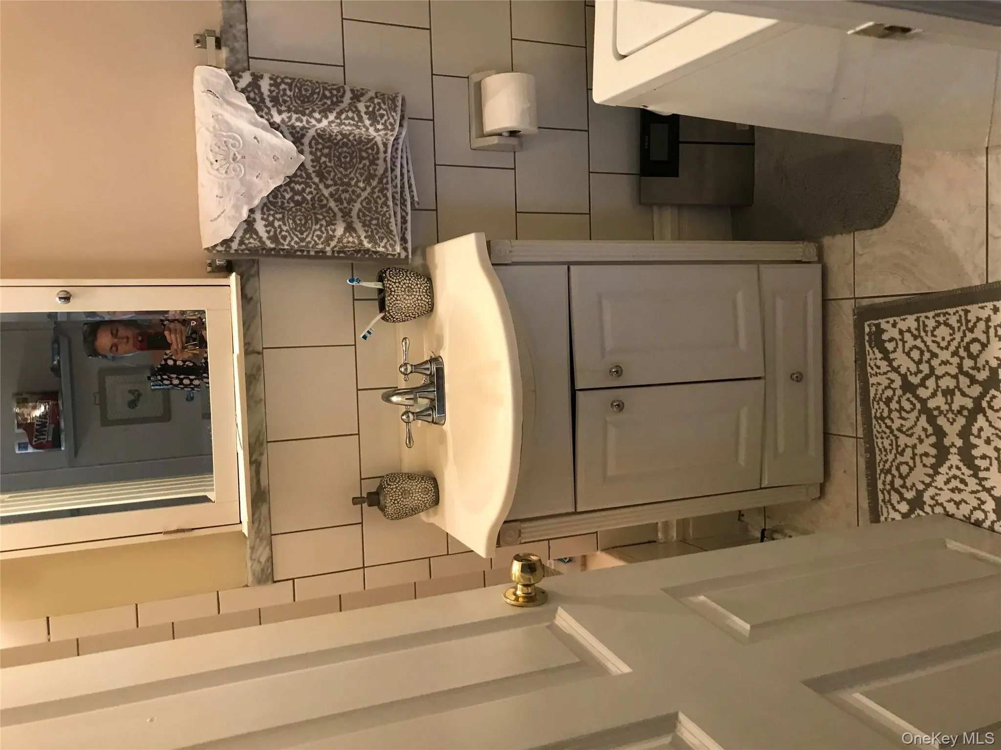 Bathroom with vanity, decorative backsplash, and tile walls Bathroom with vanity, decorative backsplash, and tile walls